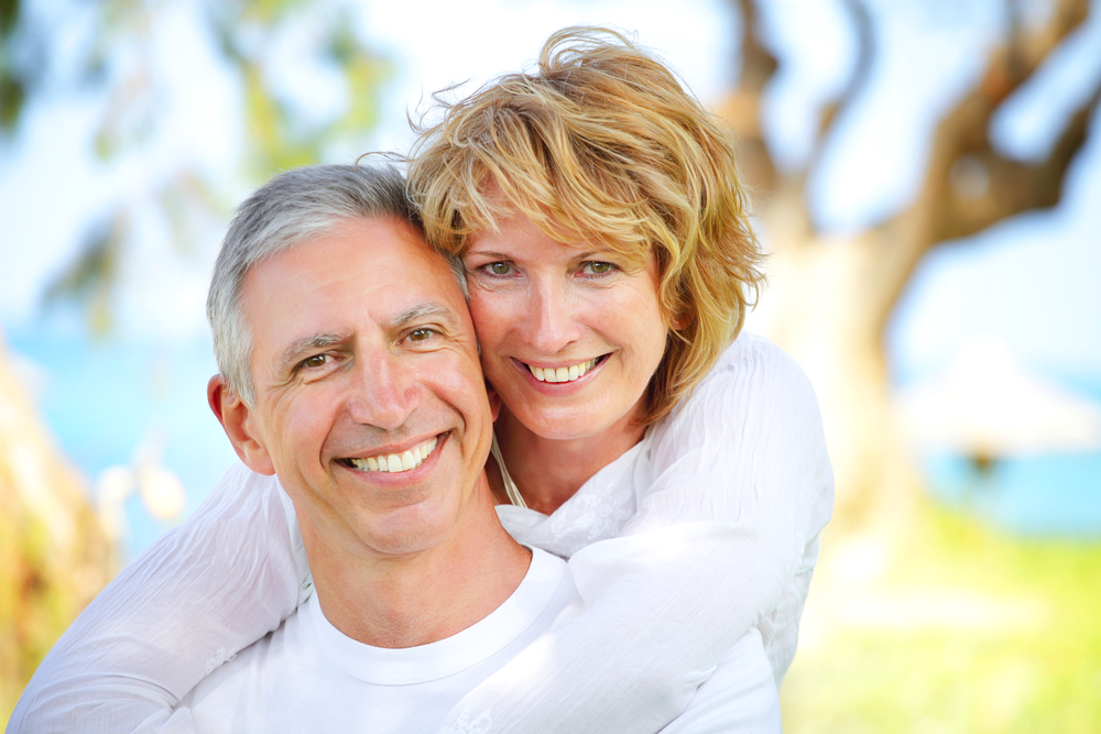 couple smiling on isolated background after having arestin treatment